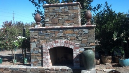this is a picture of a stacked stone fireplace constructed in the backyard of a resident's home in Roseville, California.